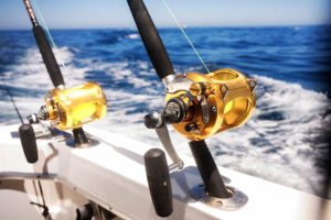Two big fishing reels on a boat in the ocean.
