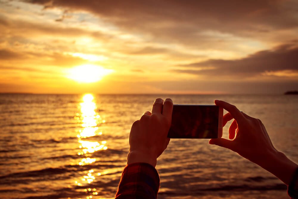 Someone taking a picture of a sunset in Key West.